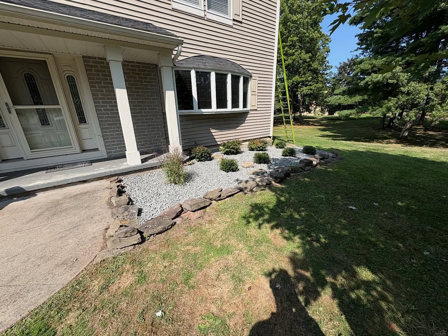 After - clean stone border with white gravel and new plantings