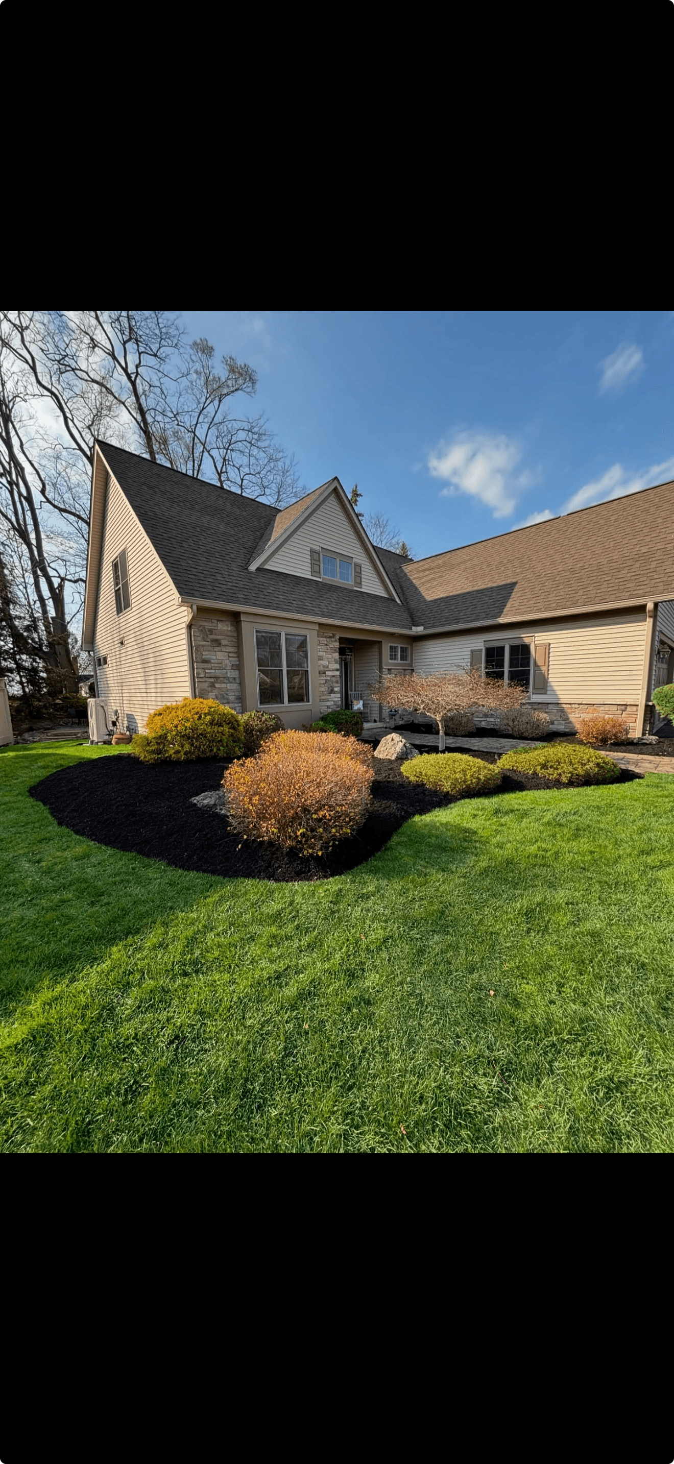 Residential property with fresh dark mulch beds and manicured ornamental shrubs